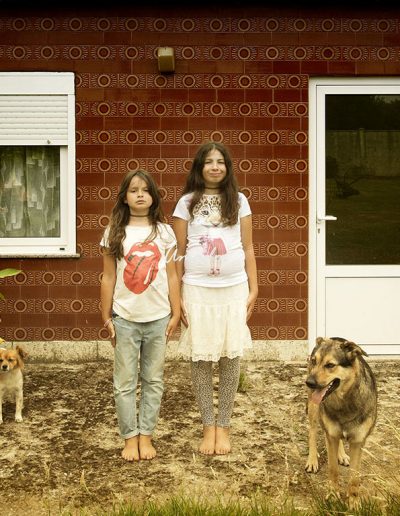 foto de doos niñas frente a una casa con perros