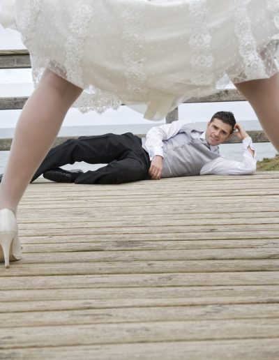 entre las piernas de la novia se ve un poco mas atrás al novio tumbado en el suelo coon un perro a su lado