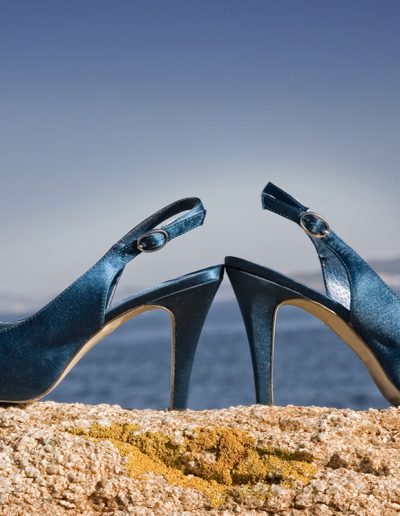 zapatos de novia azules sobre una roca con el azul del mar y el cielo de fondo