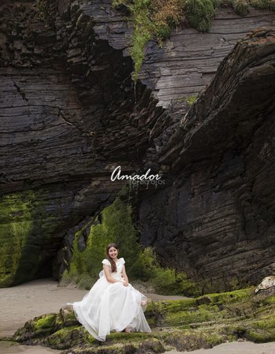 foto de niña con vestido de comunión junto a unas rocas
