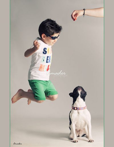 foto de niño con gafas de sol saltando al lado de un perro