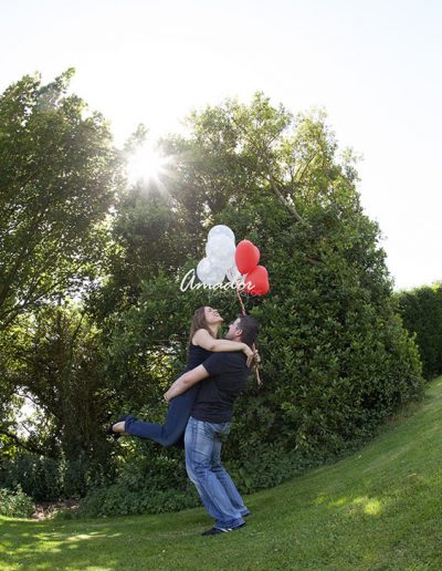 foto de pareja mientras ella sostiene unos globos