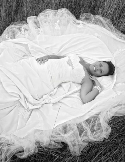 foto de novia tumbada sobre su vestido en el campo