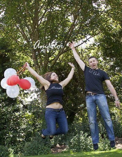 foto de pareja saltando mientras ella sostiene unos globos